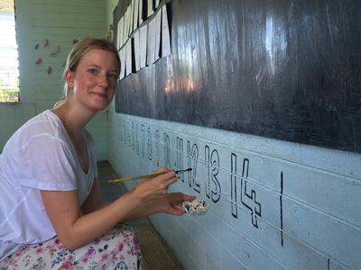 Care & Community Alternative Schoolies volunteer painting numbers on a wall