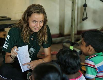 Children learn English with an Alternative Schoolies volunteer