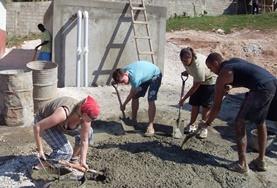 Jamaica Building volunteers in Jamaica mix cement during the construction of a new house.