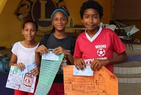 Belize Local children in Belize show off posters they made for a project at one of our Care placements.