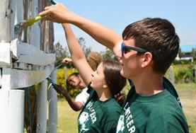 Kenya Childcare volunteers in Kenya paint playground equipment to improve the school environment for local children.