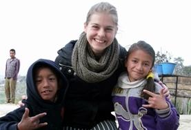 Nepal A childcare volunteer works closely with two children at a care centre in Nepal.