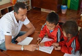 Peru A volunteer provides support for children as they finish their homework at one of our childcare placements at a school in Peru.
