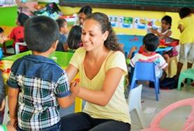 Philippines A volunteer plays an interactive game with a young boy at one of our childcare placements in the Philippines.