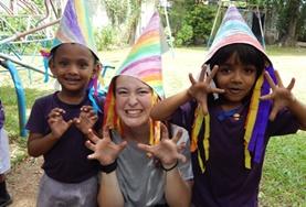 Sri Lanka A childcare volunteer in Sri Lanka runs a creative arts and crafts lesson, teaching children to make colourful hats.