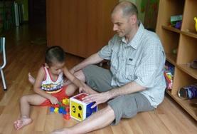 Vietnam A Care volunteer works with a child in Vietnam, playing an educational game.