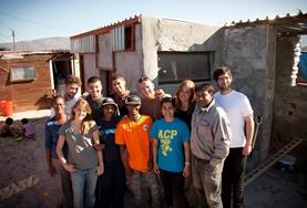 Culture & Community Volunteers and local people from a South African township work on building houses to benefit the community.