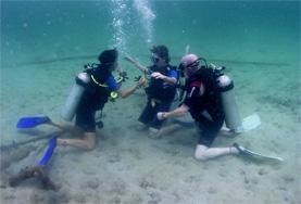 Conservation & Environment Diving & Marine Conservation volunteers learn underwater sign language during a practice dive in Cambodia.