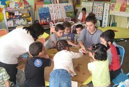 Morocco A high school student volunteering in Morocco runs an educational activity with children, under the guidance of a local teacher.