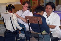 Bolivia Two high school students measure children's heart rates during a volunteer Medicine outreach in Bolivia.