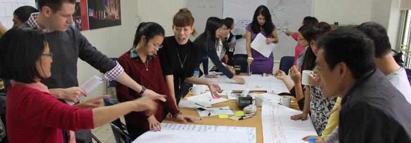Volunteers around table Projects Abroad Vietnam volunteers plan for their project around a table