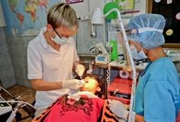 Medicine & Healthcare A Dentistry volunteer observes as a local dentist performs a procedure on a child in a Cambodian hospital.
