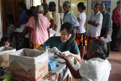 Medical volunteer tests blood sugar and blood pressure at outreach project Projects Abroad Medicine volunteer from Hong Kong tests blood sugar and blood pressure at Medical outreach camp in rural Colombo