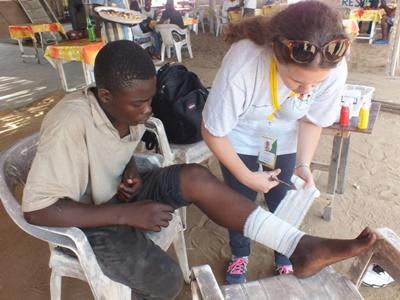 Female volunteer wrapping the wound of a patient Projects Abroad Medicine volunteer helping a local at a community outreach project in Togo