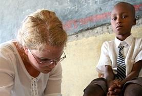 Kenya A Medicine intern helps with cleaning and dressing a child's wound at a healthcare outreach in Kenya.