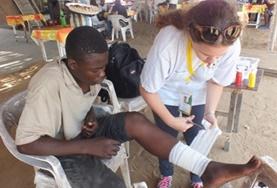 Togo A Medicine volunteer assists with dressing a patient's wound during her internship in Togo.