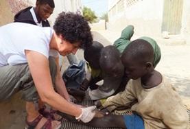Medicine & Healthcare A Nursing volunteer assists local medical staff with dressing children's wounds at our medical placement in Senegal.