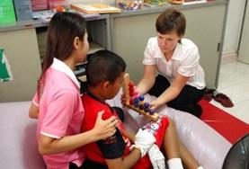 Medicine & Healthcare A trained occupational therapist shows a medical intern how to treat a disabled patient at our volunteer placement in Cambodia.