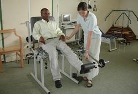 Ghana A Physiotherapy intern in Ghana uses a weights machine to exercise a patient's leg muscles at a local hospital.