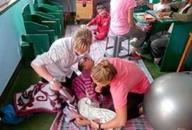 Nepal Two Physiotherapy volunteers work together to treat a disabled child during their internship in Nepal.