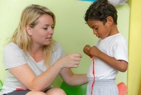 Ecuador A Social Work volunteer leads a young boy through an activity during her internship in Ecuador.