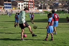 Peru A Sports volunteer teaches school children his technique for kicking a soccer on our Multi-sports project in Peru.