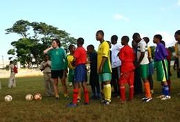 Jamaica A volunteer coaches students through a soccer drill during a school sports lesson in Jamaica.