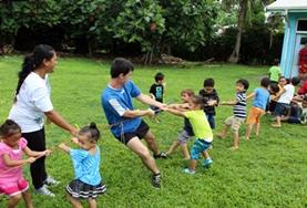 Sports A School Sports volunteer works with a group of school children during a physical education lesson in Samoa.