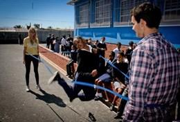 Sports Volunteers work with children in South Africa during a creative school sports lesson, helping to promote physical activity and fitness.